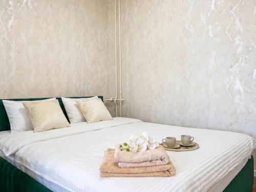 a bed with a towel and two cups and a plate on it at New stail centru in Bălţi