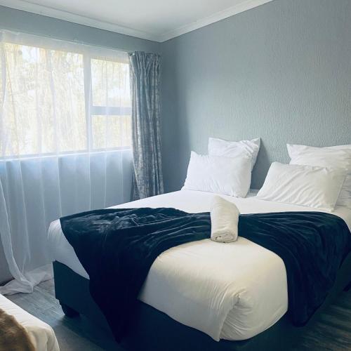 a large bed in a bedroom with a window at Number 8 in Maseru