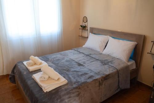a bedroom with a bed with towels on it at Villa Trigona in Kalabaka