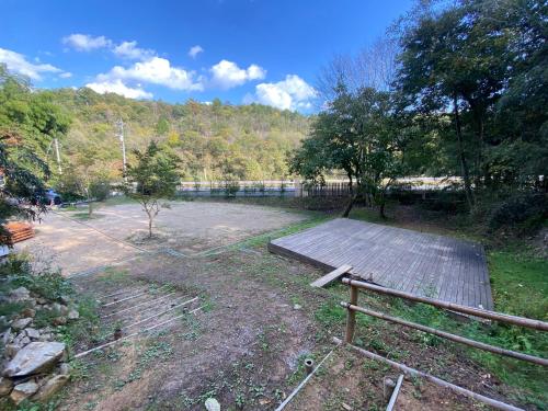 a park with a wooden ramp and a bench at うさぎのキャンプ広場 in Oguni