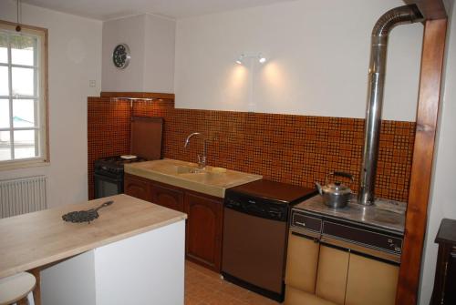 a kitchen with a sink and a counter top at Etape motards chez Fred et Flo in Compreignac