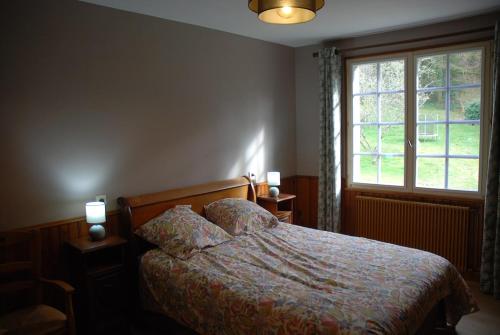a bedroom with a bed and a window at Etape motards chez Fred et Flo in Compreignac