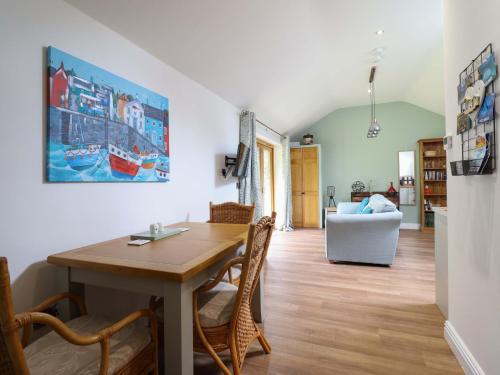 a dining room with a wooden table and chairs at Henlle Home Farm in Oswestry