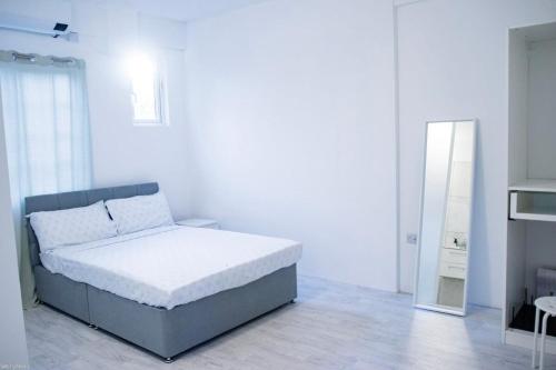 a white bedroom with a bed and a mirror at Beach Bay Terrace with Mountain views in Buccament