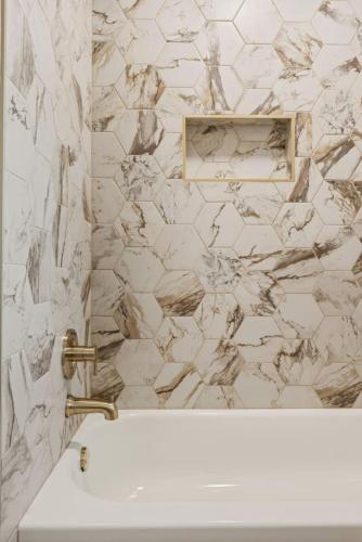 a bathroom with a sink and a marble wall at The Luxury Haus in Grove City