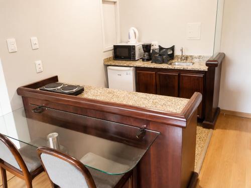 a kitchen with a counter top with a microwave at Apartamento no Hotel Prinz in Joinville