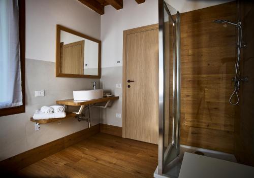 ein Badezimmer mit Dusche, Waschbecken und Spiegel in der Unterkunft Rum Oliero in Valbrenta 