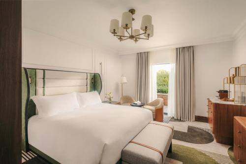 a bedroom with a large white bed and a chair at Fairmont Cheshire The Mere in Knutsford