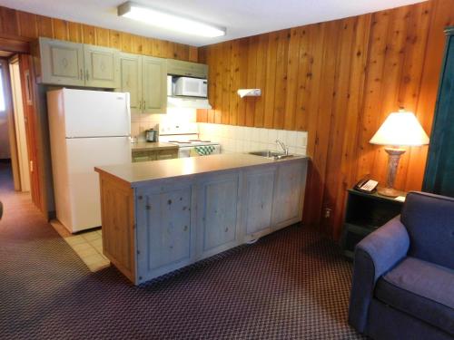 a kitchen with a white refrigerator and a counter top at Douglas Fir Resort & Chalets in Banff