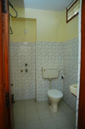 a bathroom with a toilet and a sink at SV Grand in Kākināda