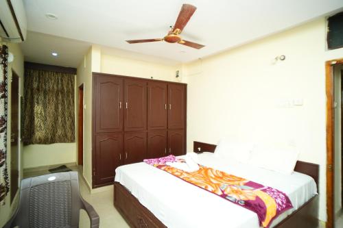 a bedroom with a bed and a ceiling fan at SV Grand in Kākināda