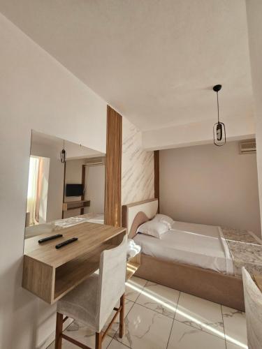 a bedroom with a bed and a desk and a mirror at Hotel Rozafa Velipoje in Baks-Rrjoll