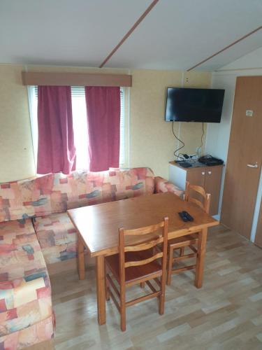 ein Wohnzimmer mit einem Holztisch und einem Sofa in der Unterkunft Petit logement tranquille in Wanchy-Capval
