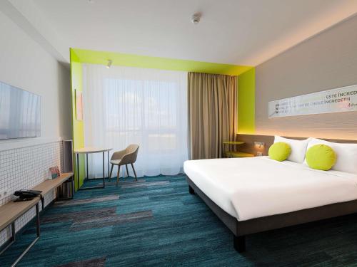 a hotel room with a large bed and a desk at ibis Styles Chisinau in Chişinău