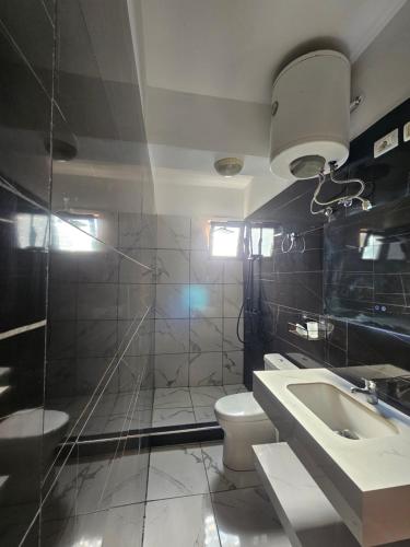 a bathroom with a toilet and a sink and a shower at Hotel Rozafa Velipoje in Baks-Rrjoll