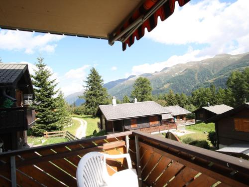 a balcony with two chairs and a view of mountains at Superb apartment with views of the Alps in Bellwald