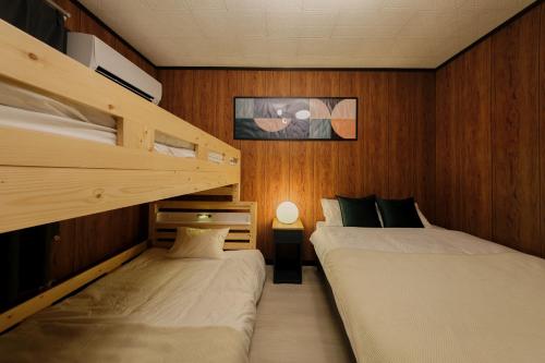 two beds in a room with wooden walls at Castle Land NAGOYA Family Friendly 5min from Station in Nagoya
