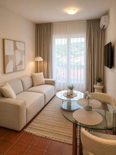 a living room with a couch and a table at Monte Aria panorama suites in Herceg-Novi