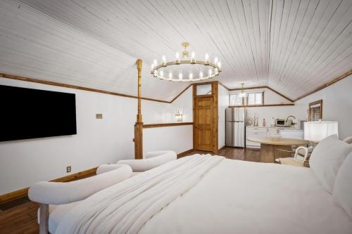 a bedroom with a large white bed and a kitchen at Chic Retreat on Broadway Street in Grove City