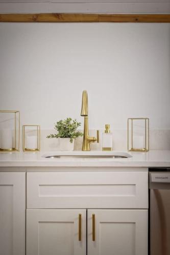a bathroom sink with a gold faucet on a counter at Chic Retreat on Broadway Street in Grove City
