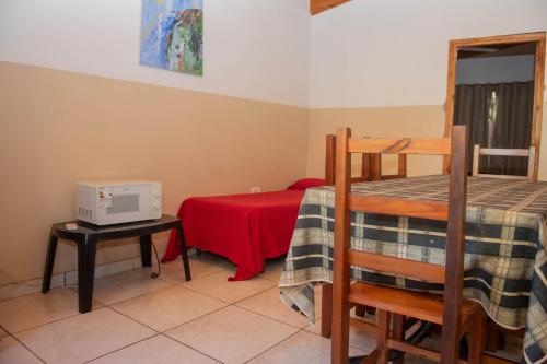 a room with a bed and a table with a microwave at El Rosedal Cataratas in Puerto Iguazú