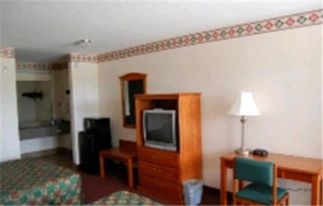 a hotel room with a television and a desk and chair at Express Inn & Suites Westwego in Westwego
