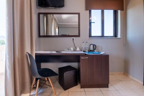 a bathroom with a sink and a mirror and a chair at GardenBlue By Gereoudis in Kolymvari