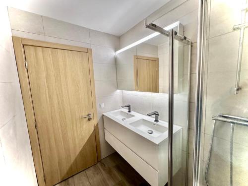 a white bathroom with a sink and a shower at Estúdio com cozinha e casa de banho! in Bragança