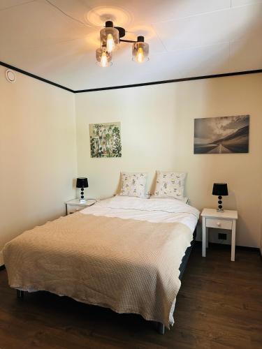 a bedroom with a large bed with two tables at Olden Apartment with Panorama view in Olden