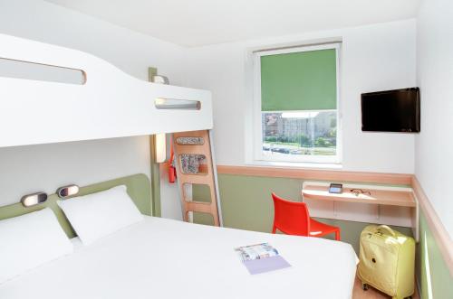 een slaapkamer met een bed, een bureau en een raam bij ibis Budget Clermont Ferrand Centre Montferrand in Clermont-Ferrand