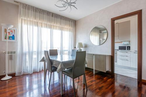 a dining room with a table and chairs and a mirror at Fiera Suite Relax in Ponte Galeria