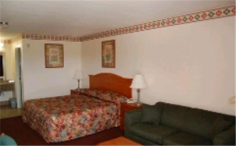 um quarto de hotel com uma cama e um sofá em Express Inn & Suites Westwego em Westwego