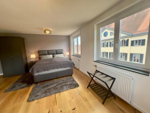 a bedroom with a bed and two windows at TIME OUT Apartments in Balingen