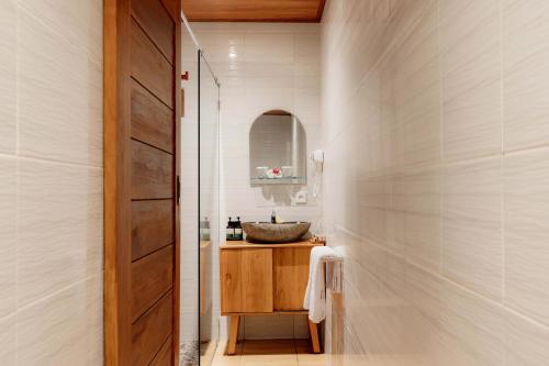 a bathroom with a sink and a mirror at Uma Nandhi Villa Ubud in Tegalalang