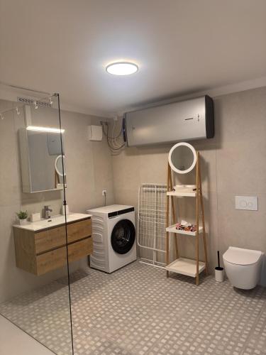a bathroom with a washing machine and a washer at Tisza-tó Porta in Tiszafüred