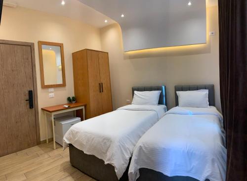 a bedroom with two beds and a mirror at SR99 Hotel in Tirana