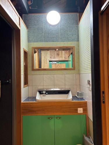 a small bathroom with a sink and a sink at 赤瓦のお宿みあげむい in Kunigami