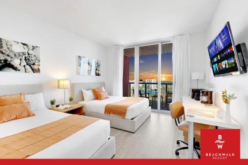 a hotel room with two beds and a television at Upper-Floor Studio Balcony Sleeps 4 in Hallandale Beach