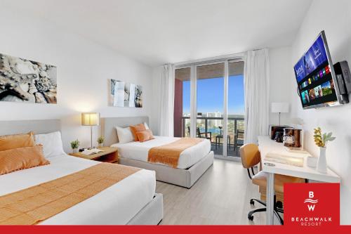 a hotel room with two beds and a flat screen tv at Upper-Floor Studio Balcony Sleeps 4 in Hallandale Beach