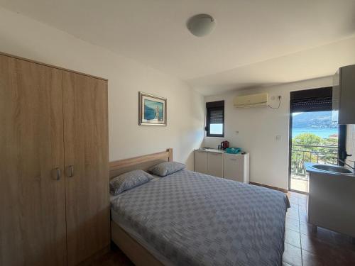 a small bedroom with a bed and a window at Julija 1 in Igalo
