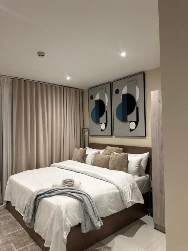 a bedroom with a large bed and two mirrors at Summers luxury at Bantree in Accra