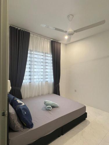 a bedroom with a large bed with a window at Seroja Homestay Gopeng in Gopeng