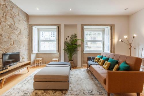 a living room with a couch and a tv at Old Stone Flats by Host Wise in Porto