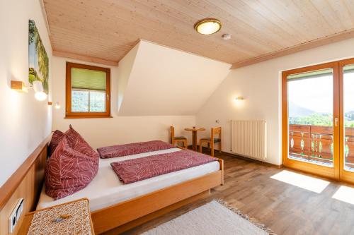 a bedroom with a bed and a large window at Ferienhaus Enzi in Weissbriach
