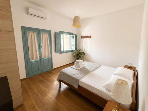 a bedroom with a bed and a green door at Apocalypsis Houses in Skala