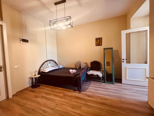 a room with a bed and a chair in it at One bedroom apartment in Tbilisi City