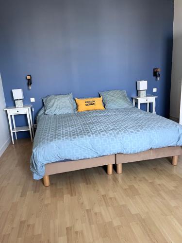 a bedroom with a bed with a blue wall at Ker Lucie in Crozon