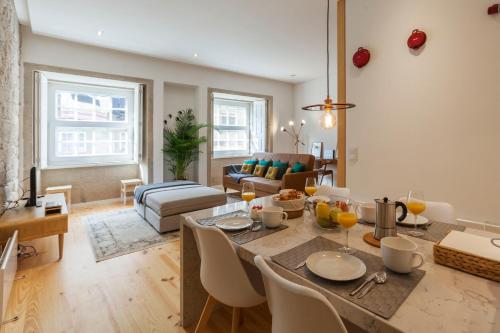 a kitchen and living room with a table and chairs at Old Stone Flats by Host Wise in Porto