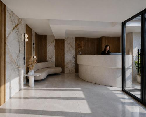 a woman sitting at a counter in a lobby at Harmony Hotel Nafplio in Nafplio