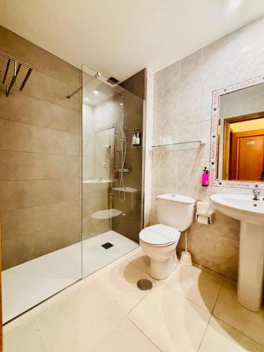a bathroom with a shower and a toilet and a sink at Hotel Atalaya II in Portonovo
